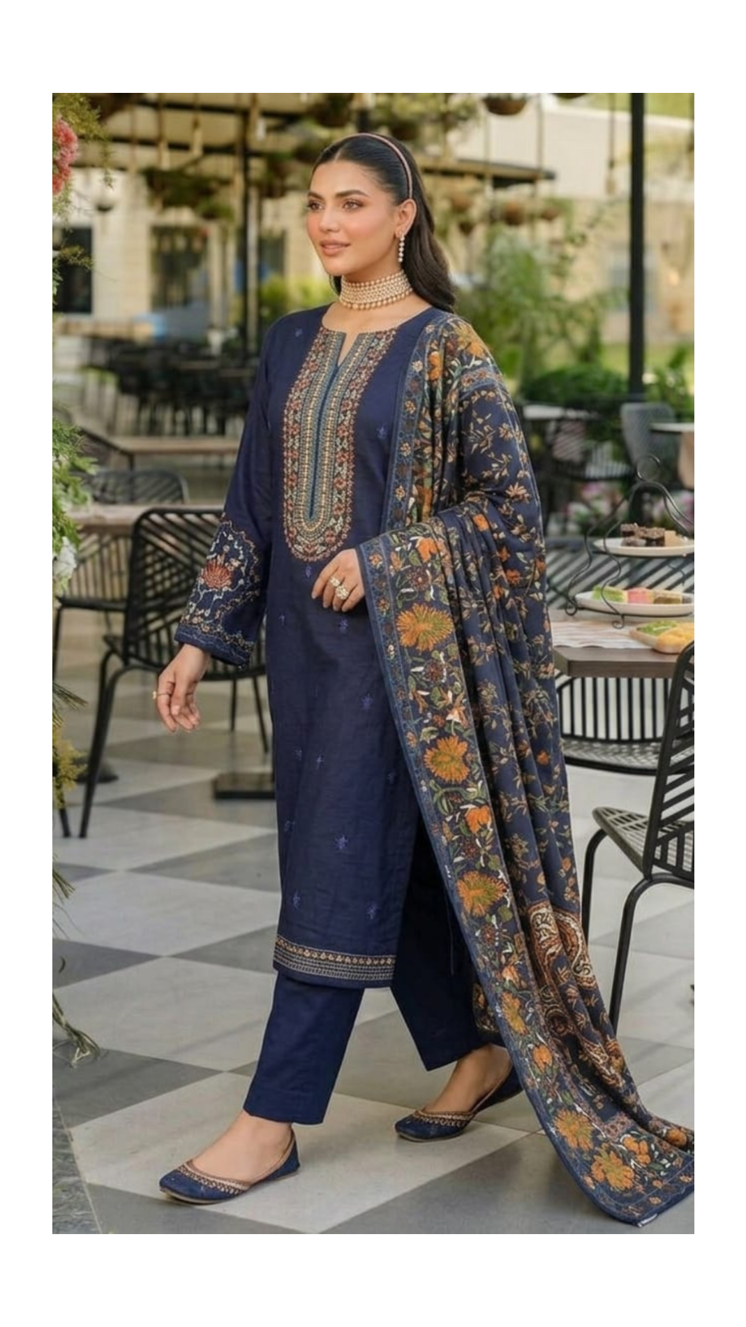 Woman in a navy blue embroidered outfit with a matching dupatta in an outdoor setting.